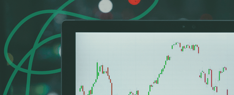 A stylized photo of a laptop with an investment graph.
