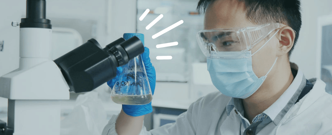 A stylized photo of someone in a lab with a microscope.