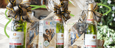 Three gift baskets featuring sparkling wine and Girl Scout Cookies.