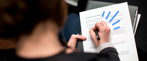 Someone taking notes on a workshop worksheet.