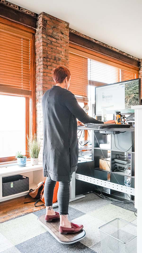 Shannan Arens, Project Manager using a balance board while working.